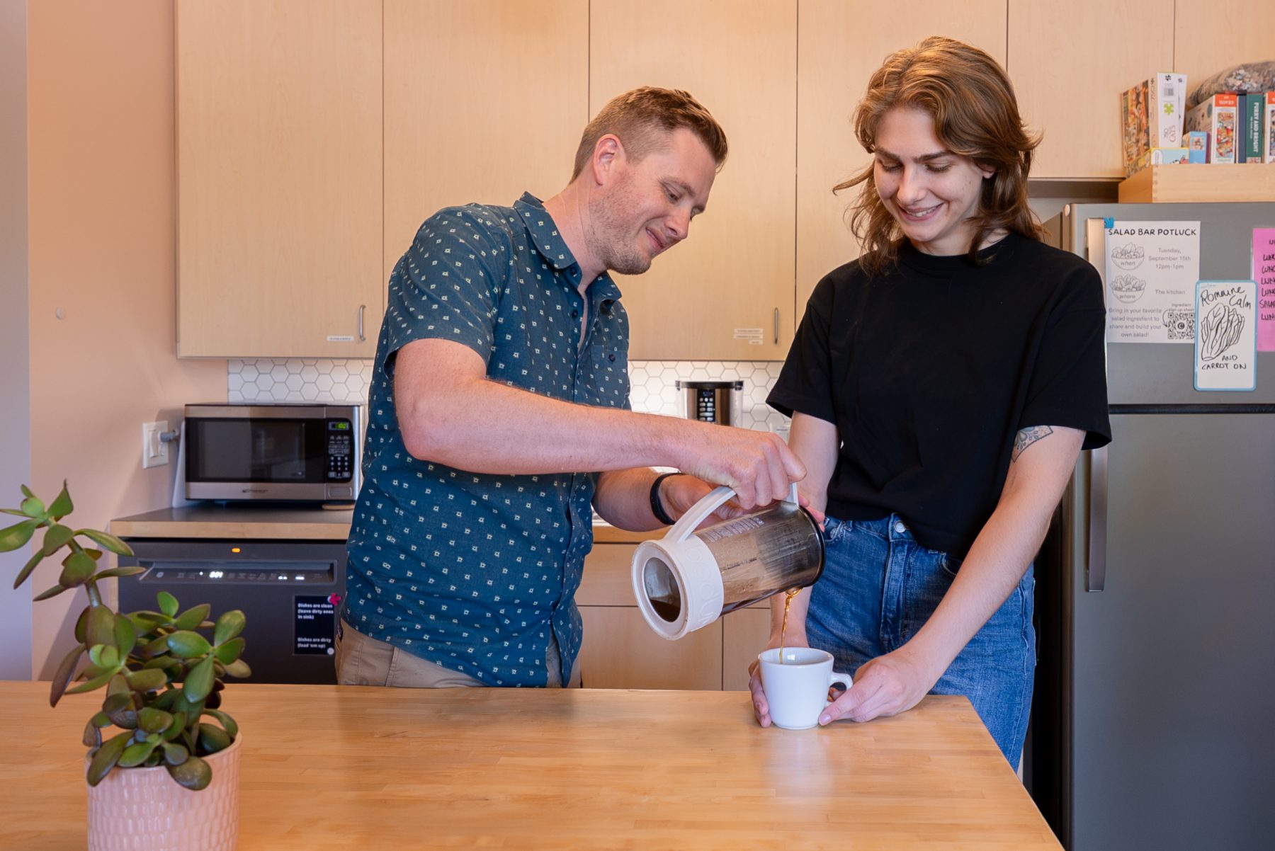 Two members pouring coffee in the Cohere kitchen